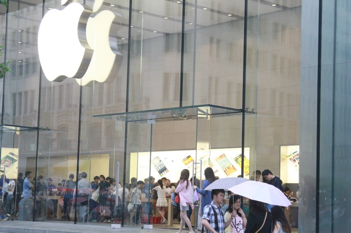 A crowded Apple Store with the Apple logo on the exterior.