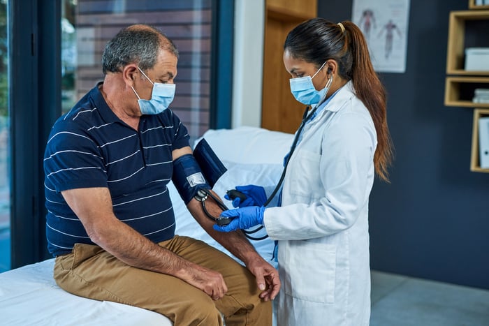 A doctor checking a patient's blood pressure.