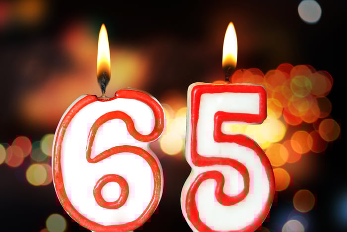 Candles in the shape of the number 65 are lit.