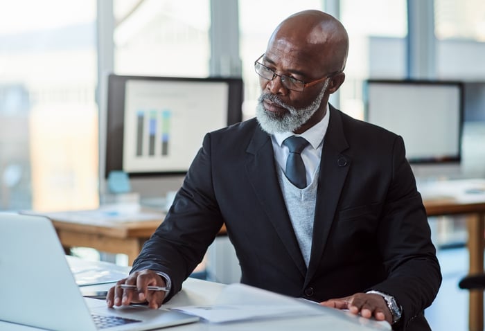 Person wearing suit looking at laptop