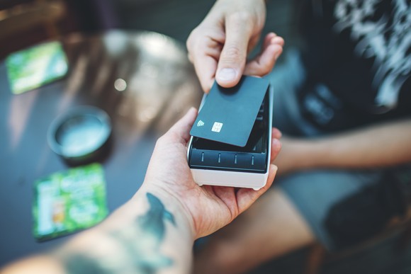 Credit card being read by a hand-held device.