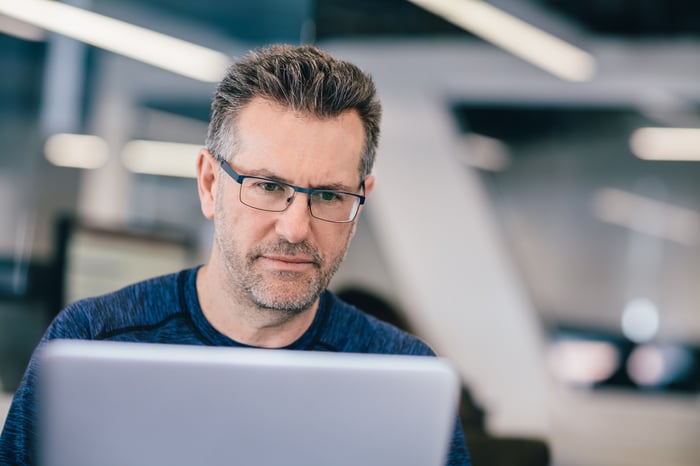 A person with a serious expression at a laptop.