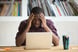 frustrated investor rubs head looks at computer