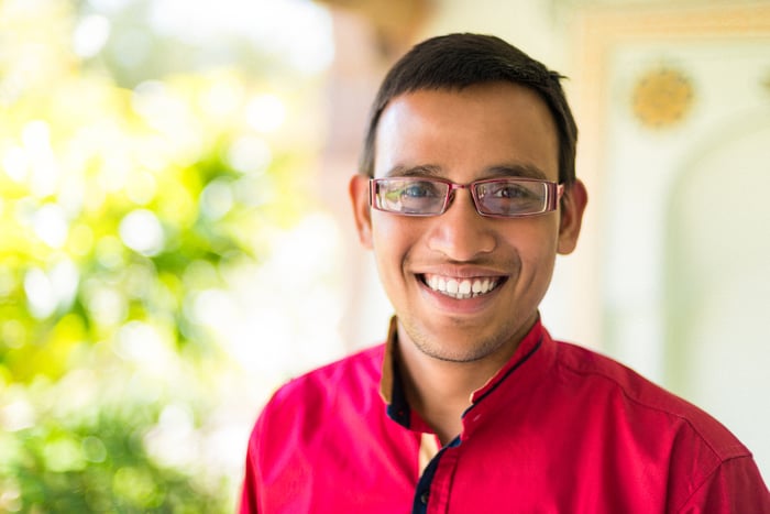 Smiling person in red shirt. 