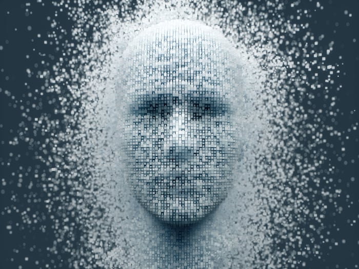 The outline of a human face emerging from a sea of individual pixels.