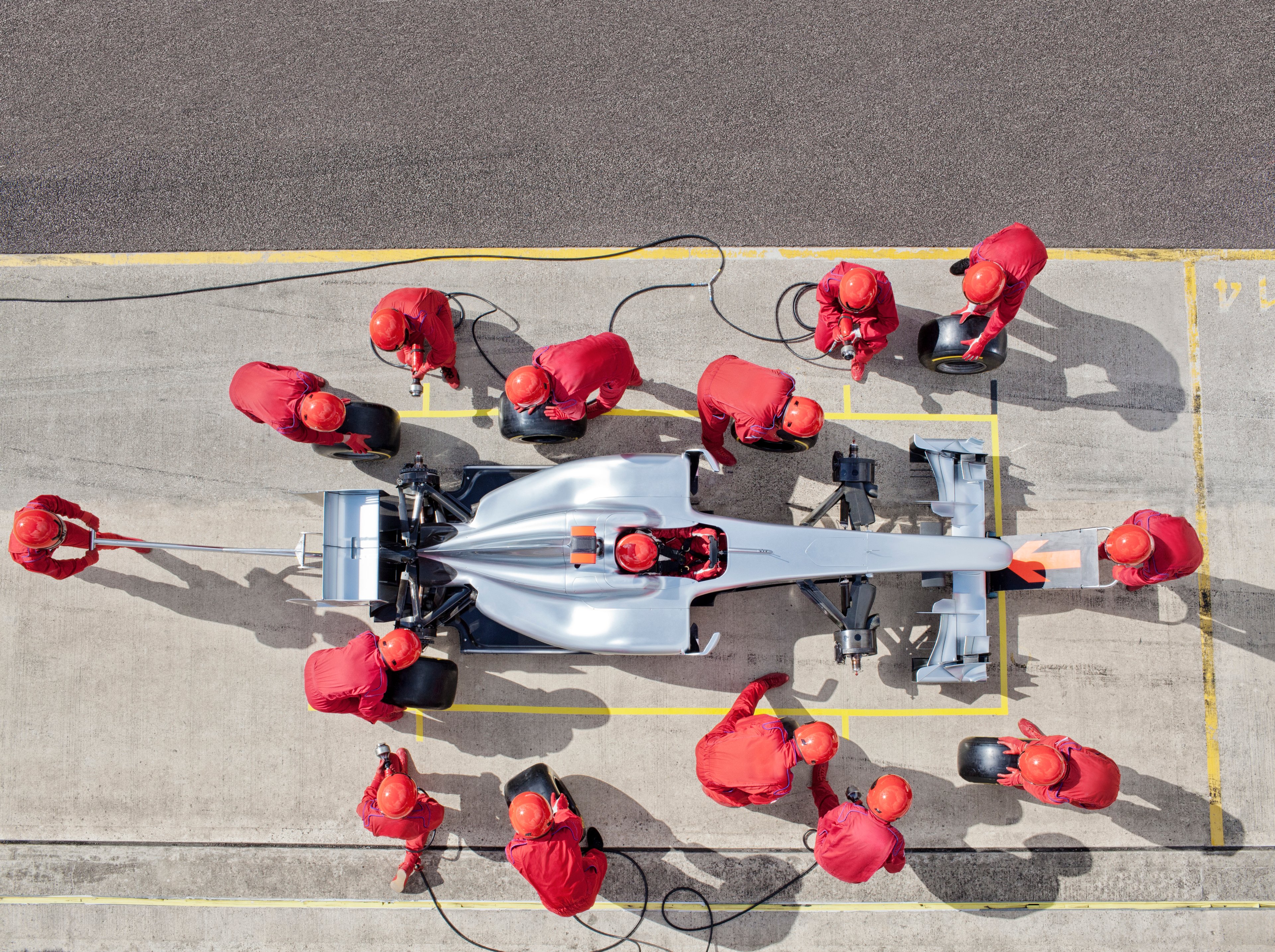 A racing crew servicing a race car in the pit lane