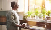 person standing in a kitchen looking out a window