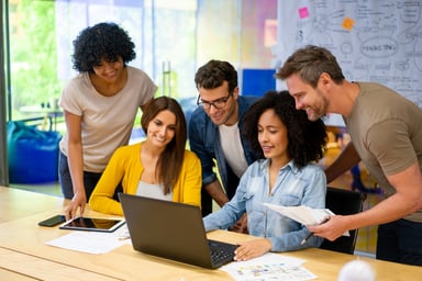 Marketing_Office_Workers_Gathered_Around_Computer-GettyImages-1332176311