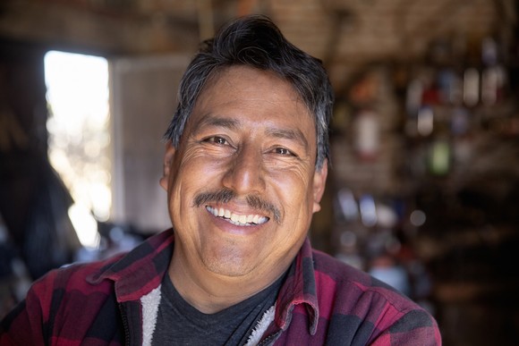 An older person is smiling at the camera.