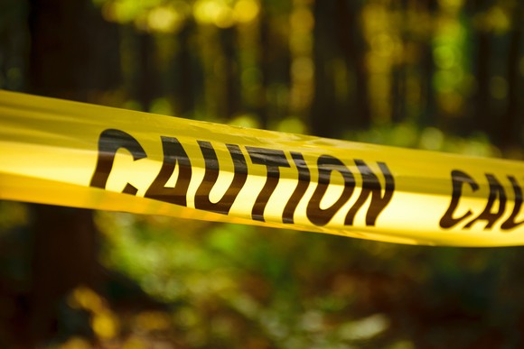 A line of caution tape extends the width of the picture.