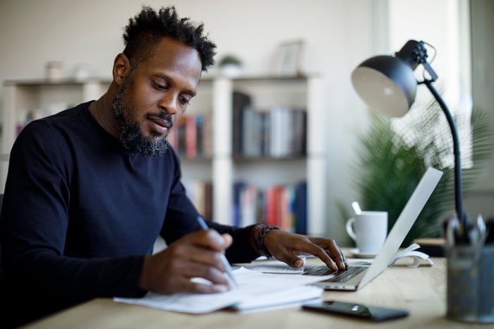 Person sitting at a desk looking at paperwork.