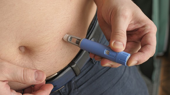 A person taking a GLP-1 injection