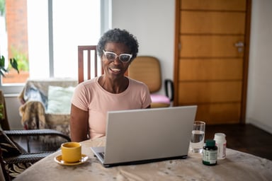 senior woman smiling laptop GettyImages-1436276188