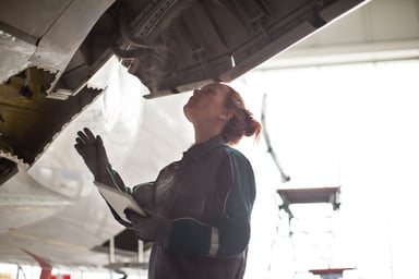 aerospace maintenance engineer inspecting airplane in hangar Getty