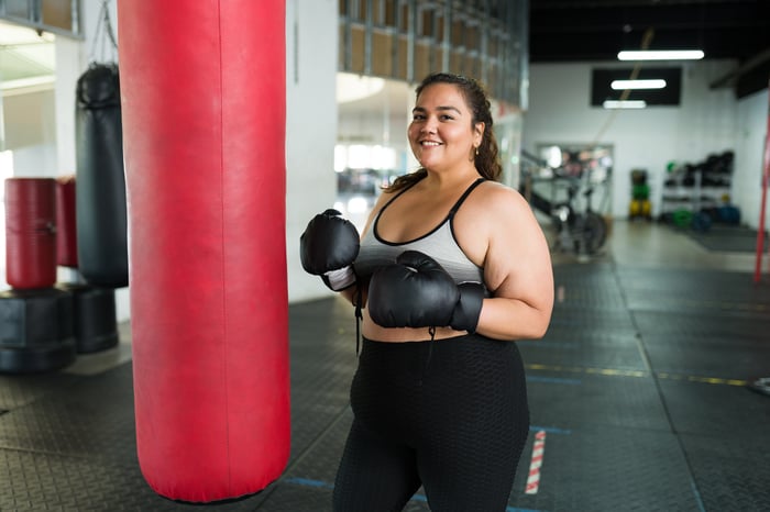 Someone is at a gym, working on a boxing bag.