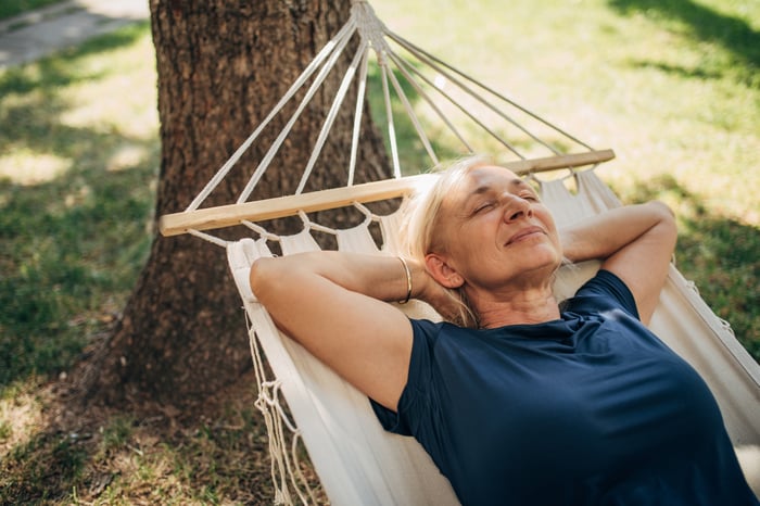 A person laying in a hammock.