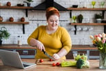 Person cutting a vegetable in a kitchen