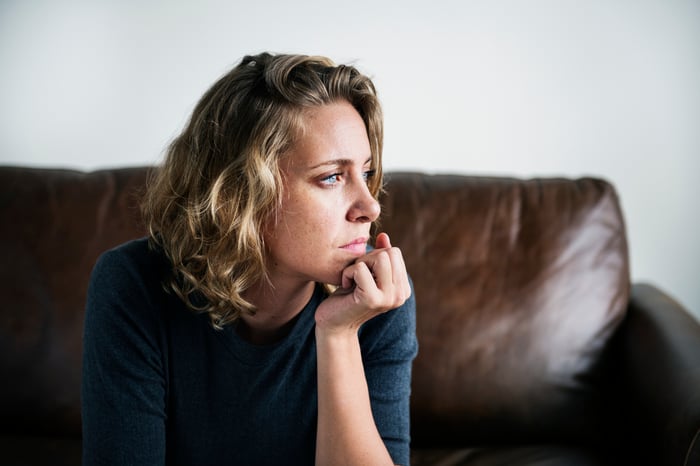 Person with a serious expression sitting on a couch.