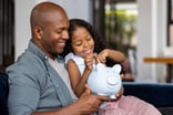 Person with a child putting money into a piggy bank