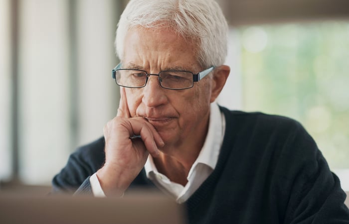 A person looking at a computer in a concerned manner. 