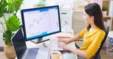Businesswoman_studying_stock_market_chart_on_a_desktop_screen