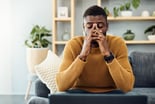 person sitting on a couch feeling worried