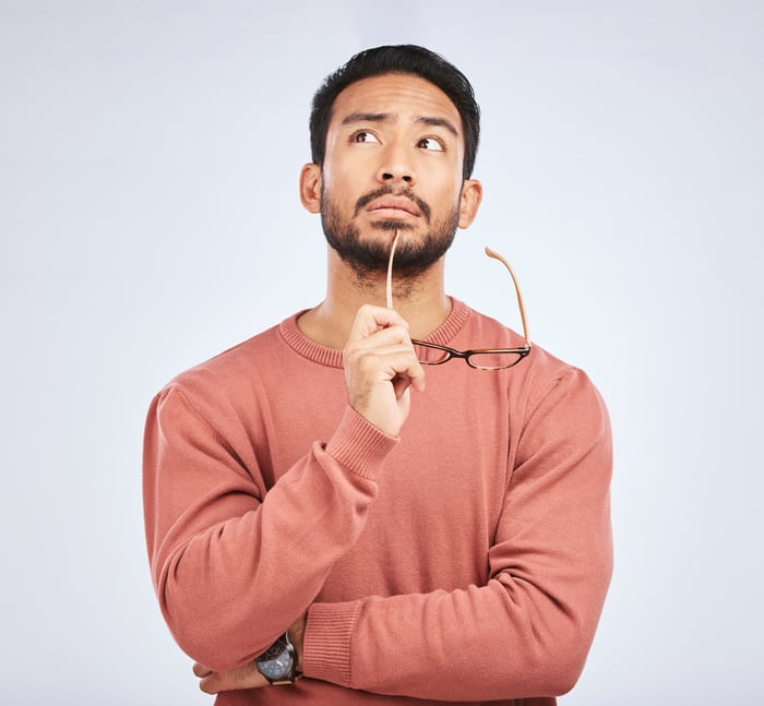 Person with glasses in hand thinking