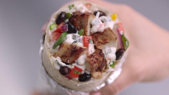 A hand holding a Chipotle burrito.