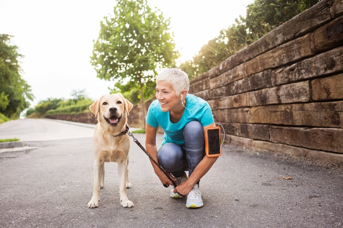 A woman getting ready to go for a run with her dog.