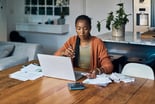 Analyst_working_with_a_laptop_and_calculator_in_a_home_office