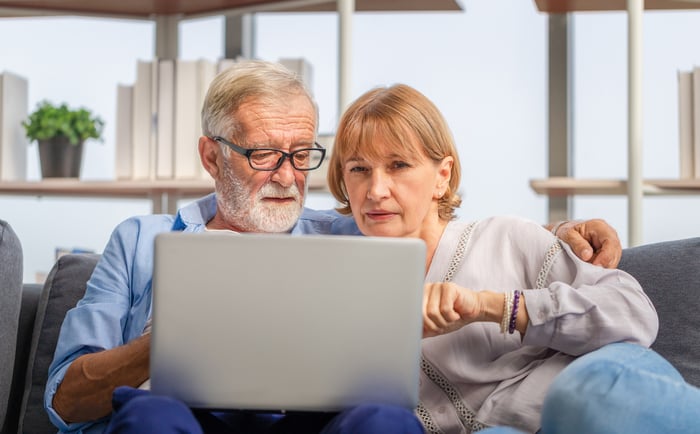Perplexed couple looking at laptop together.
