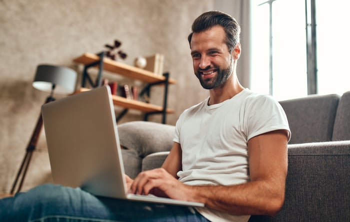 Investor in t-shirt with laptop.