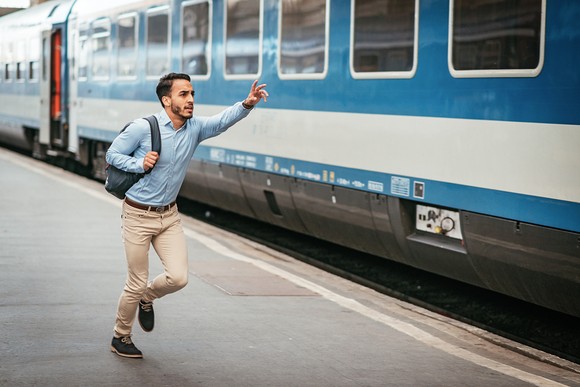 A person running after a train that they have missed.