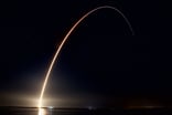 Time lapse photo of a SpaceX rocket launch at night.