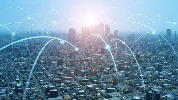 A cityscape with dozens of digital lines forming connections.