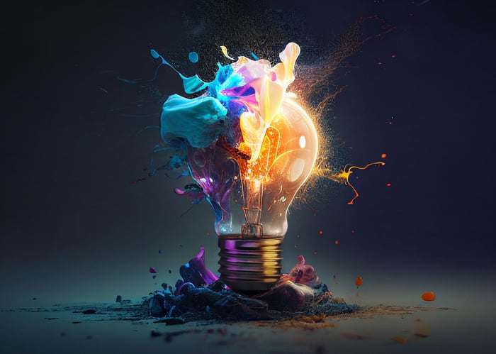 A lightbulb bursting with paint and bright colors. 