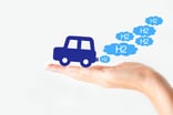 Hand holds out a fuel cell car  utting out H2 bubbles as exhaust.