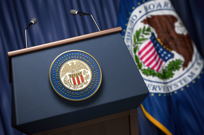 A photo of a podium with the Federal Reserve emblem on the front.
