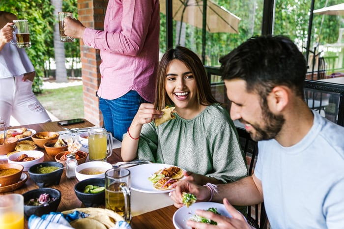 A couple eats tacos together.