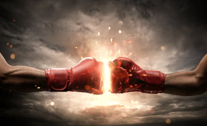 Two boxing gloves clash in the sky.