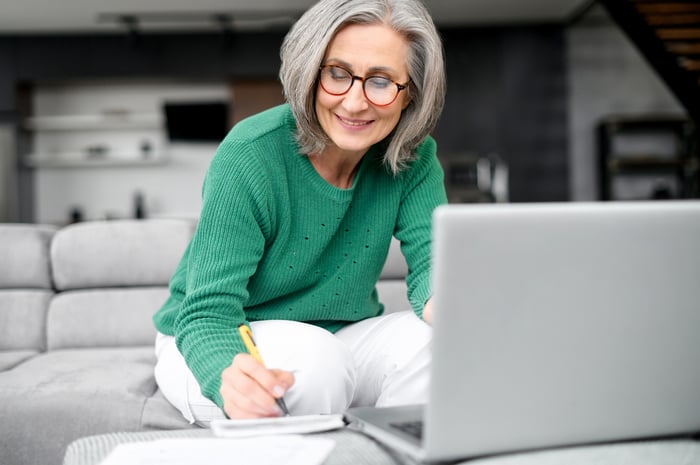 Person in living room reviewing finances. 