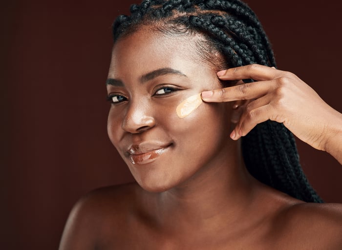 A woman putting on face cream.