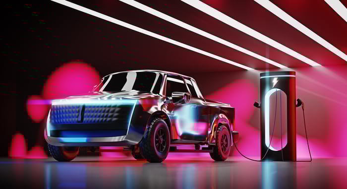 A model truck plugged into a charging station.