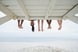 People's legs sticking out from under a boardwalk with one face