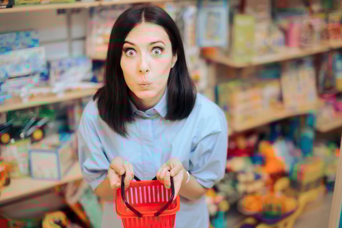 A person with a comically small shopping basket in a store.