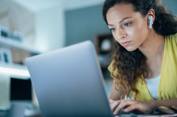 An investor studies something on a laptop at home.