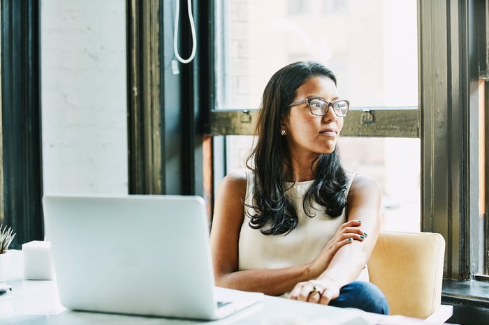 Worker sitting at desk and looking out window.