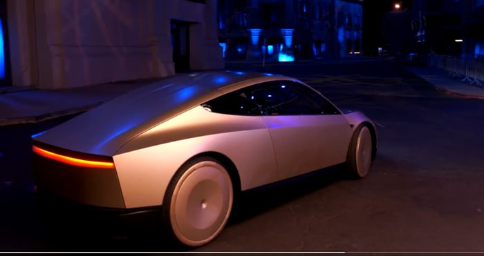 A shiny gold-colored Tesla Cybercab. 