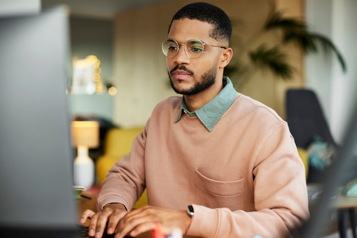 An investor works on a computer at home.