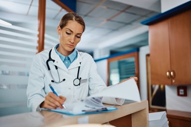 doctor writing medical reports at desk